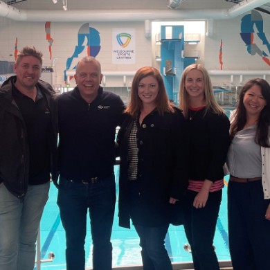 A group of people standing in front of a pool