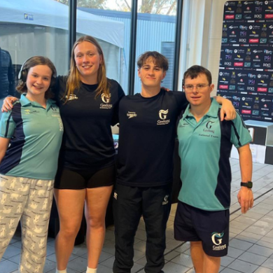 4 Geelong Swimming Club swimmers smile on pool deck together